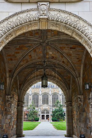 Gotischer Torbogen aus Stein, der zu einem kunstvollen Bildungsgebäude der University of Michigan führt, das architektonische Eleganz und Geschichte präsentiert