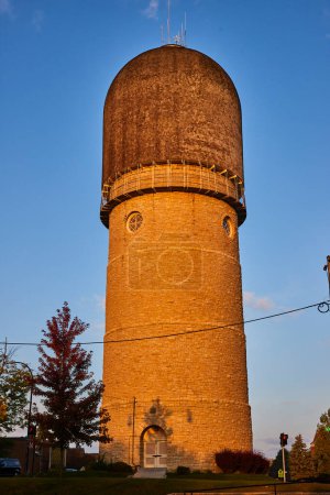 Historic Ypsilanti Water Tower in Michigan bathed in golden sunrise light, showcasing its industrial architecture and modern telecommunications use.