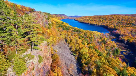 Vibrant autumn foliage surrounding a serene lake, captured from a high vantage point by a drone in Ontonagon County, Michigan, 2017