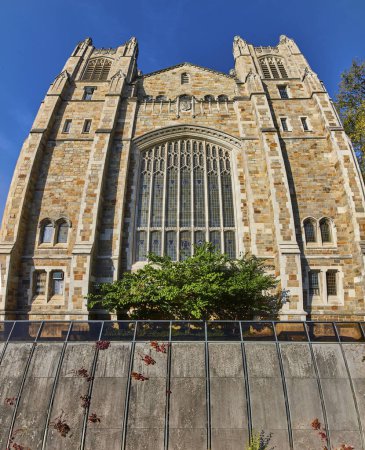 Gotische Revival-Kirche mit detailliertem Mauerwerk vor blauem Himmel an der University of Michigan, Ann Arbor, die Geschichte inmitten städtischen Grüns präsentiert