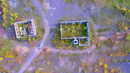 Aerial view of autumnal decay at abandoned Quincy Mines in Michigan, showcasing natures reclamation over dilapidated buildings