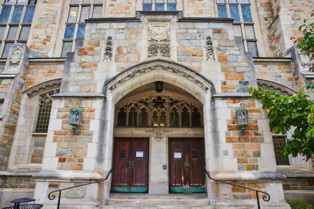 Grand Gothic Entrance of University of Michigan Law Quadrangle, showcasing intricate stonework and verdant surroundings