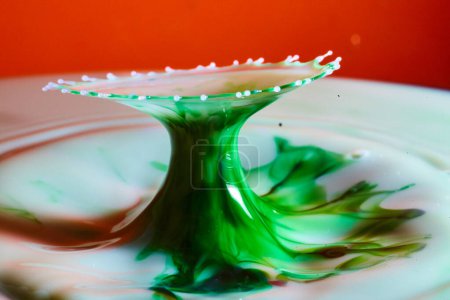 Green Liquid Splash Against Red Backdrop in Fort Wayne, 2017 - A Captivating Display of Fluid Dynamics and High-Speed Photography