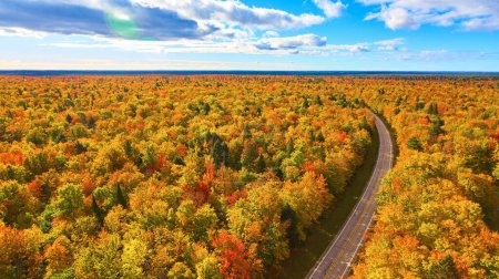 Breathtaking aerial view of a winding road through vibrant Michigan autumn landscape, taken by a DJI Phantom 4 drone in 2017
