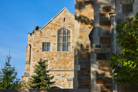 Bâtiment en pierre de style gothique à l'Université du Michigan à Ann Arbor, mettant en valeur le patrimoine architectural et la tradition académique par une journée ensoleillée.