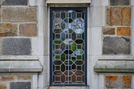 Téléchargez les photos : Fenêtre gothique en verre plombé dans un mur de pierre à l'Université du Michigan Law Quadrangle, mettant en valeur l'artisanat intemporel et le patrimoine architectural. - en image libre de droit