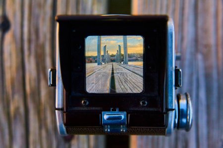 Vintage-TLR-Kamera, die einen ruhigen Blick auf die Stadt bei Sonnenaufgang von einem hölzernen Pier aus bietet, in Houghton, Michigan, Herbst 2017.