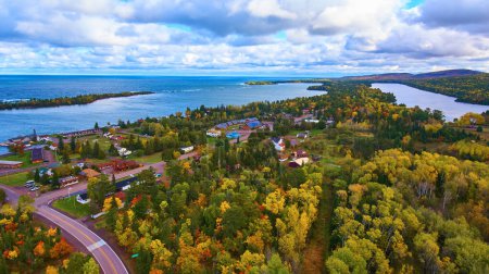 Aerial view of a serene coastal village in Copper Harbor, Michigan with vibrant fall foliage and expansive Lake Superior, captured in 2017 by a DJI Phantom 4 drone.