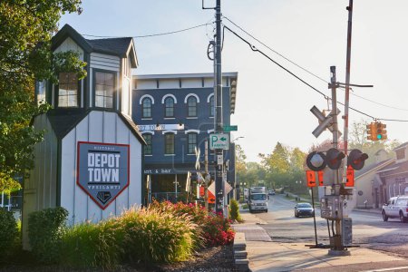 Photo for Historic Depot Town Ypsilanti building, morning traffic and railroad crossing during golden hour in Michigan - Royalty Free Image