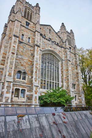 Architecture gothique de la University of Michigan Law Quadrangle, un bâtiment historique emblématique au milieu d'éléments modernes à Ann Arbor, sous un ciel couvert.
