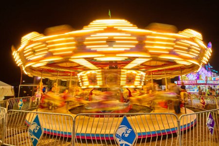 Téléchargez les photos : Carrousel animé en mouvement la nuit au cours de 2017 Allen County Fair, Indiana - Long Exposure Shot - en image libre de droit