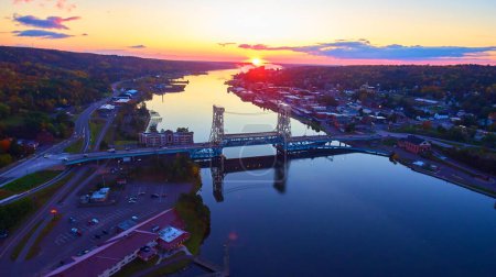 Aerial sunrise view of the Portage Lake Lift Bridge connecting two sides of a serene Michigan town, Autumn 2017