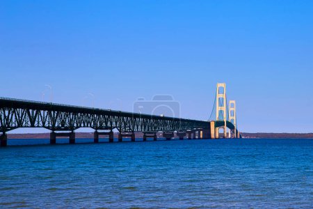 Daytime view of the majestic Mackinac Bridge spanning across serene blue waters in Michigan, Fall 2017 - Symbol of engineering and connectivity