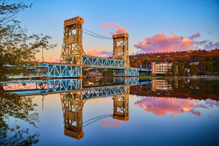 Sunset view of Portage Lake Lift Bridge casting a perfect reflection on calm waters in Houghton, Michigan, Fall 2017