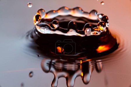 Photo for Dramatic close-up of a golden water droplet creating a crown-like splash, captured in high-speed in Fort Wayne, Indiana, 2017 - Royalty Free Image