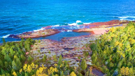 Vue aérienne du havre de cuivre, Michigan, montrant le mélange vibrant de couleurs automnales le long du rivage rocheux avec le bleu profond du lac Supérieur