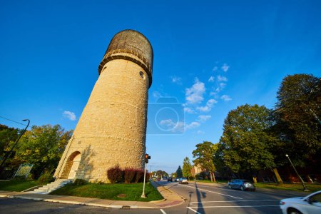 Photo for Golden hour view of historic Ypsilanti Water Tower in Michigan, surrounded by early autumn foliage in a serene suburban setting. - Royalty Free Image