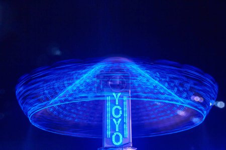 Photo for Long exposure of YOYO Chair-O-Planes at Allen County Fair Grounds, Indiana, 2017, creating a blue light swirl in the night sky, symbolizing dynamic motion and energy. - Royalty Free Image