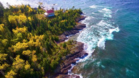 Aerial View of Charming Lighthouse Amidst Autumnal Woodland in Copper Harbor, Michigan