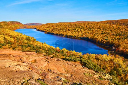 Foto de Impresionante paisaje de otoño en el lago en las nubes, Michigan, follaje vibrante se encuentra con Crystal Blue Lake - Imagen libre de derechos