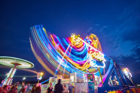 Téléchargez les photos : Image vibrante de longues expositions de manèges de carnaval en mouvement au crépuscule, Allen County Fair Grounds, Indiana, 2017 - en image libre de droit