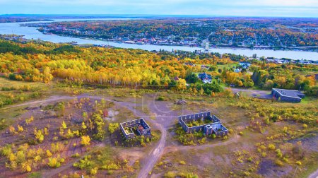 Aerial view of vibrant autumn landscape, old Quincy Mines structures in Houghton, Michigan, and waterfront town in the distance