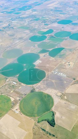 Vista aérea de la agricultura moderna en Colorado, 2021 - Campos de cultivo circulares verdes vibrantes y patrones de carretera sistemáticos capturados desde el vuelo del avión