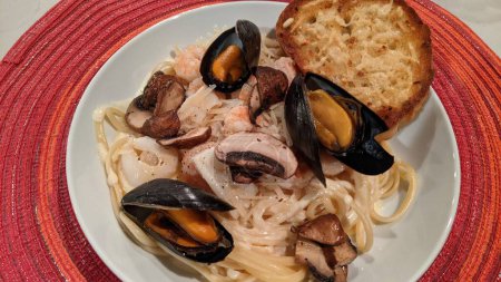 Köstliche Meeresfrüchte-Pasta mit Muscheln und Garnelen, serviert mit Knoblauchbrot in gemütlichem Ambiente, Fort Wayne, Indiana, 2021