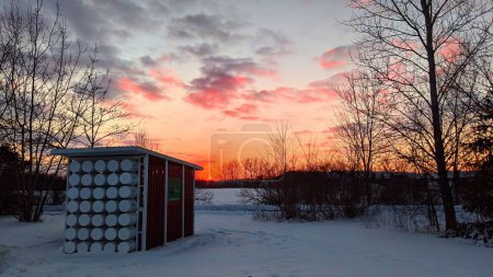 Lebendiger Wintersonnenuntergang über der umweltfreundlichen Kompostierungsanlage in Fort Wayne, Indiana, unterstreicht nachhaltiges Leben vor einer ruhigen, schneebedeckten Landschaft