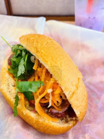 Téléchargez les photos : Sandwich vietnamien au boeuf Banh Mi fraîchement préparé servi dans un restaurant vietnamien décontracté, 2023. Parfait pour un déjeuner copieux ou des thèmes de street food. - en image libre de droit