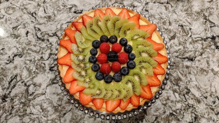 Vibrant homemade fruit tart on granite countertop, showcasing fresh berries and kitchen setting, Fort Wayne, Indiana 2021