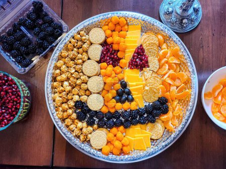 Vibrant snack platter at a festive home gathering in Fort Wayne, Indiana on Halloween 2021, featuring caramel popcorn, Oreos, fresh fruit, and cheese.