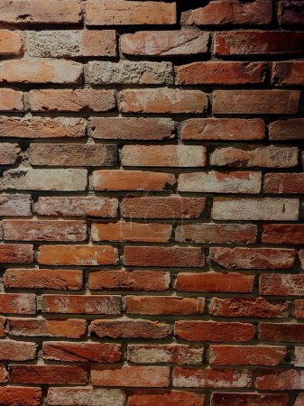 Nahaufnahme einer traditionellen Backsteinmauer mit rustikalem Charme in Bloomington, Indiana, 2022, die Variationen in Textur und Farbe in einem koreanischen Fried Chicken Restaurant zeigt.