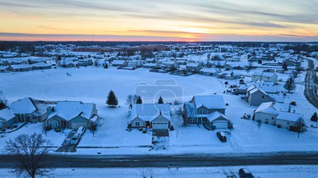 Sereno atardecer de invierno sobre la manta de nieve en el suburbio residencial uniforme, Fort Wayne, Indiana - captura de la tranquilidad y el cambio estacional.