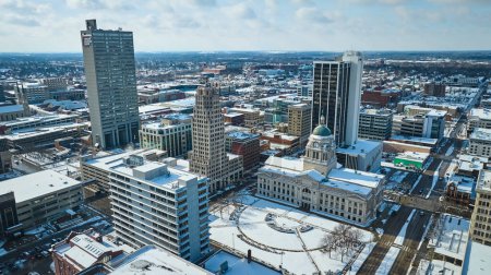 Téléchargez les photos : Downtown Fort Wayne, Indiana sous une couverture d'hiver sereine, mettant en valeur le contraste d'un gratte-ciel moderne et d'un palais de justice historique. - en image libre de droit