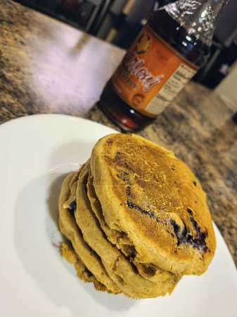 Inviting breakfast scene featuring homemade blueberry pancakes in a cozy Fort Wayne kitchen, enhanced by syrup and indoor lighting.