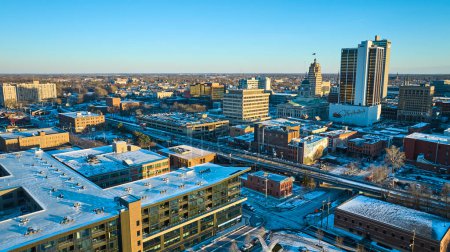 Winter morning over downtown Fort Wayne, Indiana showcases urban life with snow-laden rooftops, morning light, and active streets.