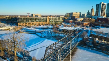 Winter morning over Fort Wayne, Indiana revealing serene scenes of snow-covered Promenade Park and Wells Street Bridge