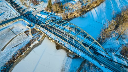 Aerial view of Martin Luther King Bridge in Fort Wayne, Indiana, spanning icy St. Marys River in winter