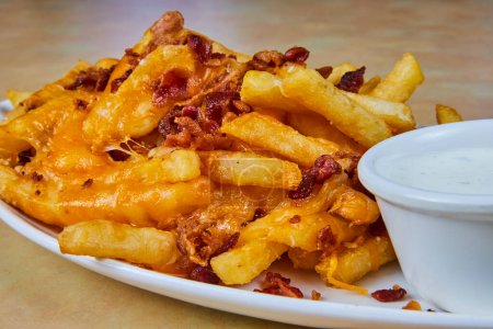 Indulgent cheesy bacon fries served with cool ranch dip, capturing the essence of comfort food in Fort Wayne, Indiana.