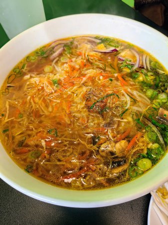 Soupe de nouilles asiatiques fraîche et vibrante, servie chaude à Fort Wayne, Indiana - une invitation à savourer une cuisine réconfortante authentique.