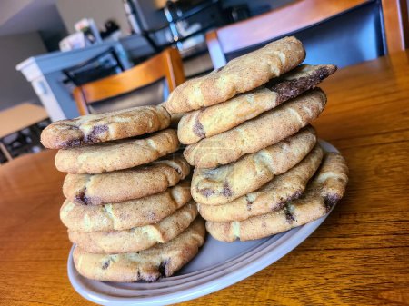 Freshly baked chocolate chip cookies on a cozy kitchen table in Fort Wayne, inviting indulgence in home comforts.