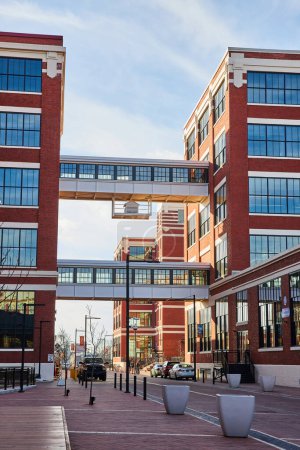 Téléchargez les photos : La rénovation urbaine moderne à Electric Works, Fort Wayne, Indiana, montre des bâtiments dynamiques en briques rouges reliés par une passerelle piétonne, symbolisant la connectivité et l'innovation.. - en image libre de droit