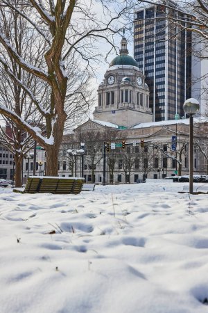 Serenity in Snow: A tranquil morning at Fort Waynes Freimann Square, capturing the contrast of historic courthouse and modern skyscraper.