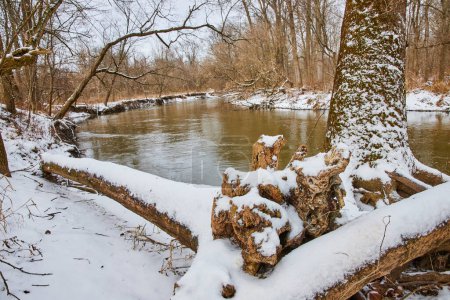 Heiterer Winter River im Cooks Landing County Park, Indiana - ein sanft fließender Fluss inmitten einer verschneiten Waldlandschaft