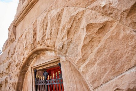 Nahaufnahme komplizierter Sandsteinarchitektur und roter Tür auf dem Lindenwood Cemetery, Fort Wayne, die Geschichte und Handwerkskunst zeigen.