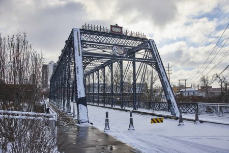 Wintereinbruch auf der historischen Wells Street Bridge in der Innenstadt von Fort Wayne, Indiana, die die Mischung aus urbaner Architektur und Natur zeigt.