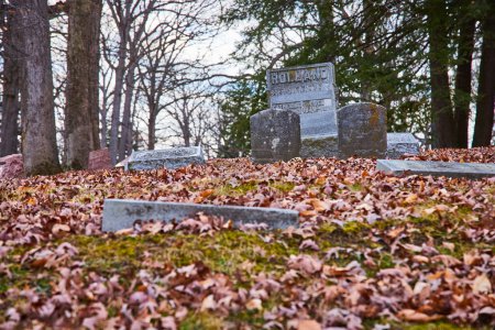 Heiterer Herbst Blick auf bemooste Grabsteine im historischen Lindenwood Cemetery, Fort Wayne, Indiana, symbolisiert die Erinnerung und den Lauf der Zeit.