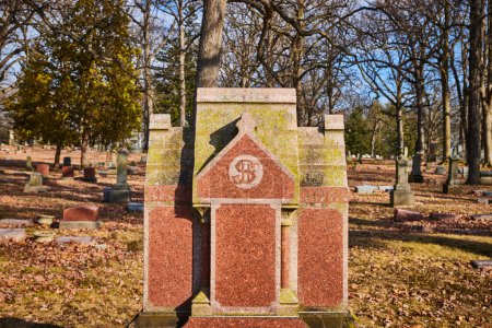 Pierre tombale gothique recouverte de mousse au cimetière Lindenwood, Fort Wayne, Indiana, histoire de signalisation passage au milieu d'un paysage d'automne tranquille.