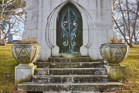 Photo for Gothic Revival mausoleum door amid weathered urns, embodying history and eternity at Lindenwood Cemetery, Indiana - Royalty Free Image